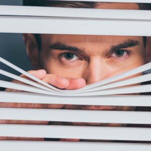 Spion spionerar genom gardiner.