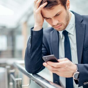 Oroad man läser SMS.