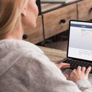 Kvinna med Facebook på laptop