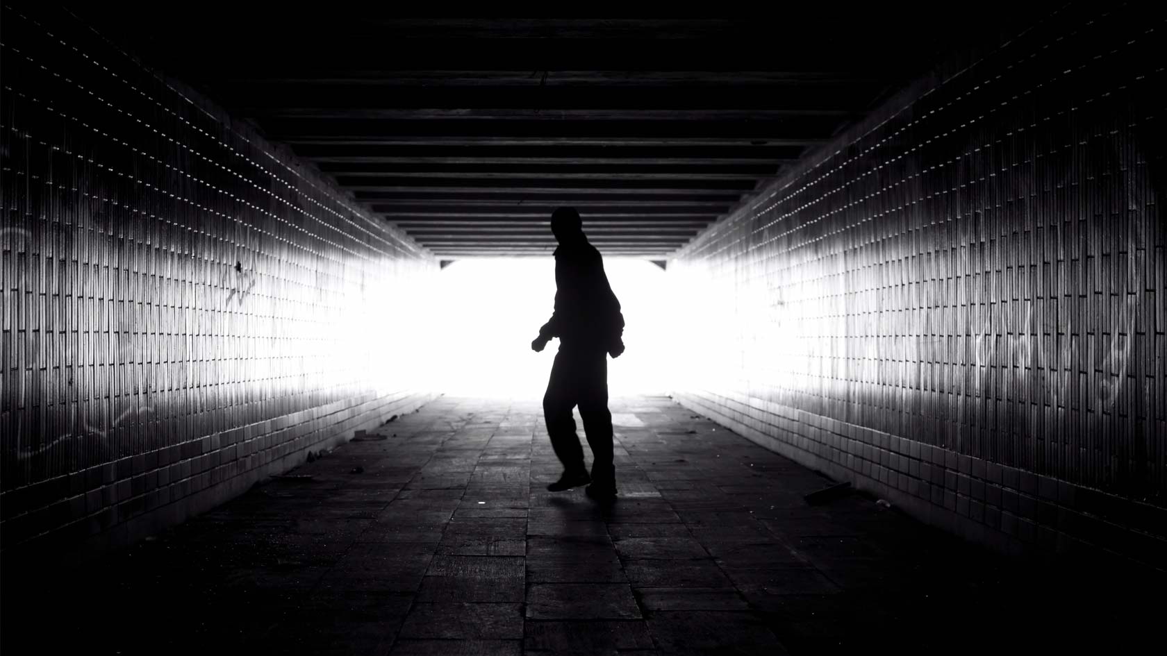 Person vänder sig om i en mörk tunnel.