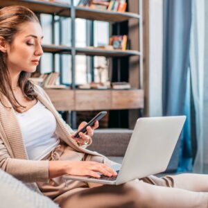 Kvinna arbetar från soffan. Hon sitter ansluten via wifi.