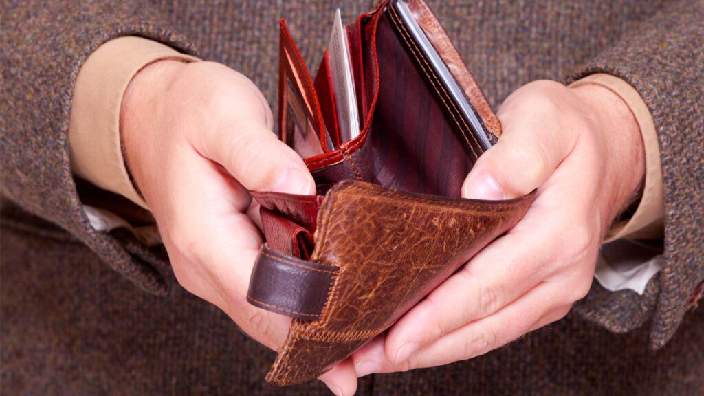 Person håller upp en tom plånbok.