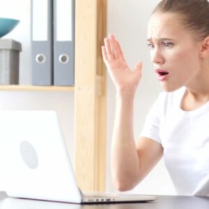 Kvinna är uppgiven framför sin Macbook.
