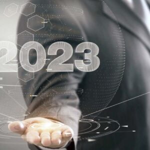 En affärsklädd person håller fram en futuristisk rendering av siffran 2023.
