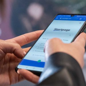 Person söker med sökmotorn Startpage på sin mobil.