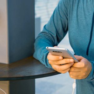 Person laddar sin mobil på en publik laddplats.
