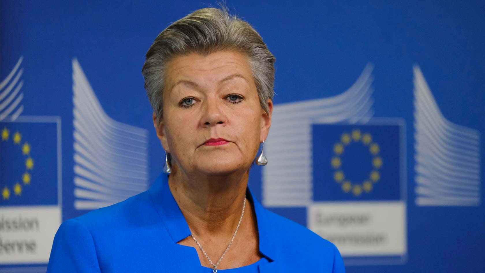Ylva Johansson med EU-kommissionens logotyp i bakgrunden.