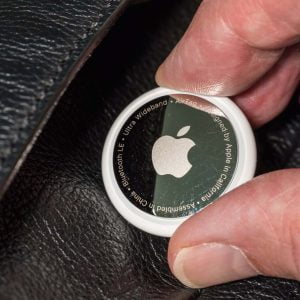 Person lägger in en Airtag i en plånbok.