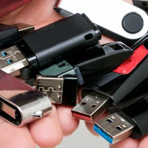 Händer fulla med olika USB-minnen.