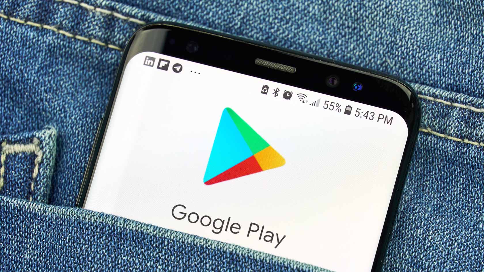 En mobiltelefon sticker upp ur en jeansficka. Google Plays logotyp syns tydligt.