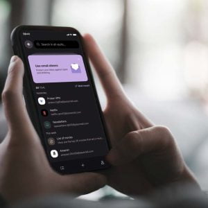 Person sitter med en mobil i handen. Mobilen visar Proton Pass-appen.