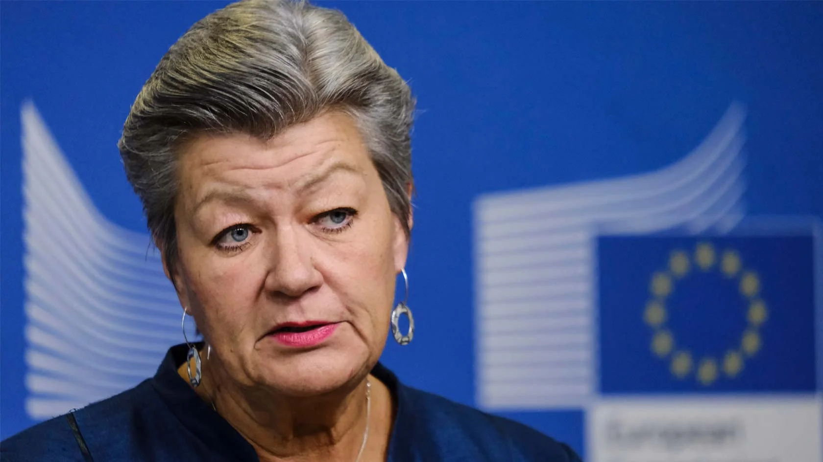 Ylva Johansson med EU-kommissionens logotyp i bakgrunden.