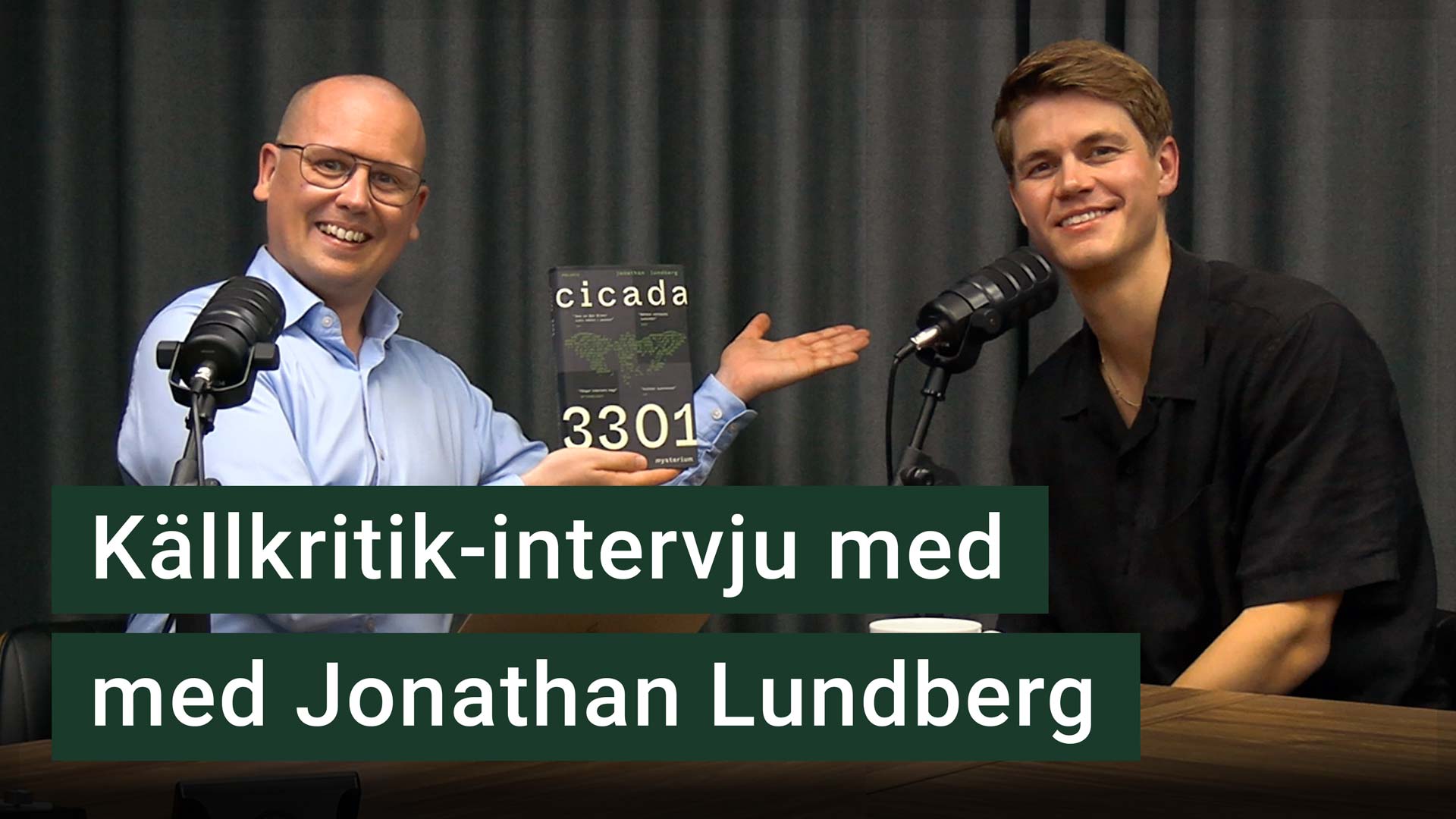 Karl Emil Nikka och Jonathan Lundberg sitter vid varsin mikrofon. Texten ”källkritik-intervju med Jonathan Lundberg” är stämplad ovanpå.