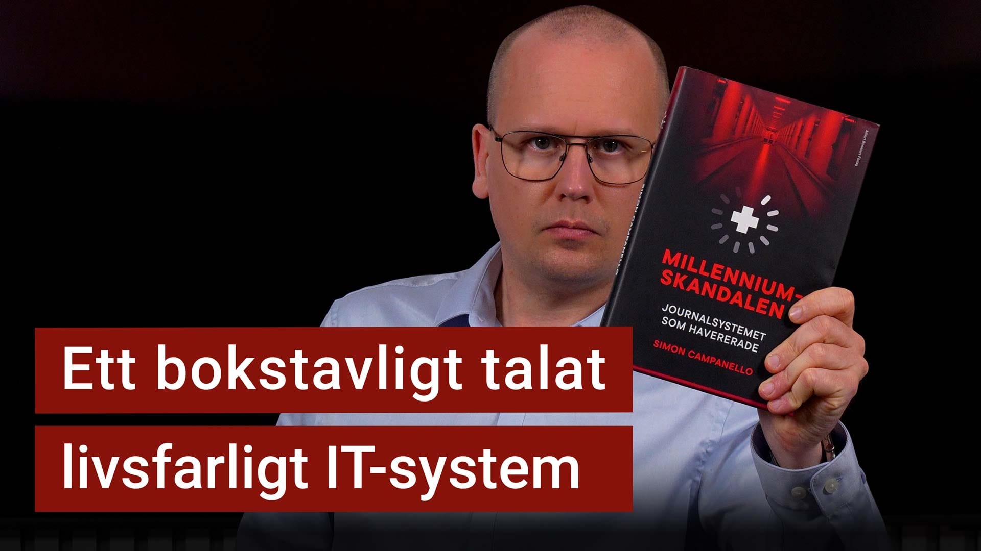 Karl Emil Nikka håller upp boken Millenniumskandalen. Texten ”ett bokstavligt talat livsfarligt IT-system” är stämplad ovanpå.