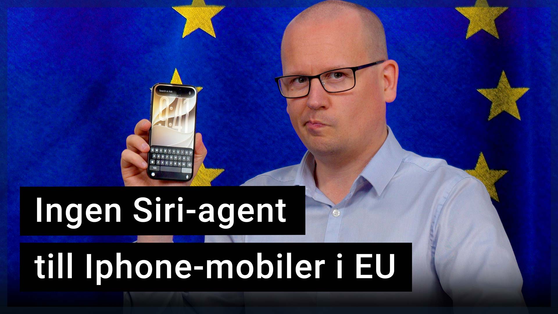 Karl Emil Nikka håller upp en Iphone som visar nya Siri-appen. I bakgrunden syns EU:s flagga.