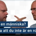 Peter Esse och Karl Emil Nikka pekar argt på varandra. Följande text är stämplad ovanpå bilden. Är du människa? Bevisa att du inte är en robot!